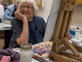 Mareike Clark, a five-year member of the Pioneer Art Club converses with friends as she paints at the Stony Plain Royal Canadian Legion. The Pioneer Art Club has their Annual spring show coming up from April 15-16 at the Stony Plain Royal Canadian Legion. - Photo by Yasmin Mayne