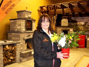 Margaret Pinsonneault, general manager of Al's Lawn & Garden, prepares to set a vase of spring flowers in an outdoor living space display at the Chatham-Kent Home & Garden Show at the John D. Bradley Convention Centre in Chatham on Friday. The show runs through Sunday. PHOTO TAKEN on Friday, April 8, 2016 in Chatham, Ont. (Vicki Gough, Chatham Daily News)