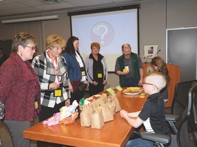 Parkland Village School Grade 4 student Carter Davidson speaks with Parkland School Division board members and staff who stopped by his “shop” during his class’ micro-society presentation to the board on April 5. - Photo by Marcia Love