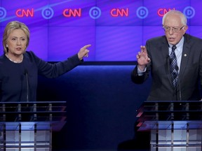 Democratic U.S. presidential candidate Hillary Clinton and rival Bernie Sanders speak simultaneously during the Democratic U.S. presidential candidates' debate in Flint, Michigan on March 6, 2016. REUTERS/Jim Young