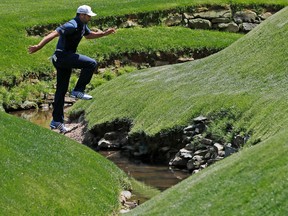 Sergio Garcia, of Spain, jumps Rae’s Creek on the 13th hole during the second round of the Masters golf tournament Friday, April 8, 2016, in Augusta, Ga. (AP Photo/David J. Phillip)