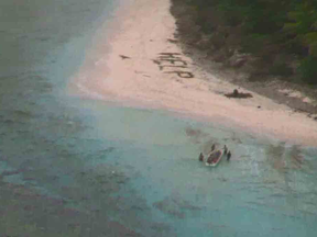 A small boat from Pulap recovers three men from the uninhabited island of Fanadik after they were discovered by a U.S. Navy plane. (Source: U.S. Navy)