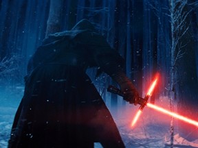 This photo provided by Disney shows, Adam Driver as Kylo Ren with his Lightsaber in a scene from "Star Wars: The Force Awakens."