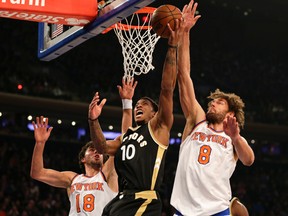 Toronto Raptors guard DeMar DeRozan (10) drives to the basket between New York Knicks center Robin Lopez (8) and guard Sasha Vujacic (18) during the first half at Madison Square Garden. (Adam Hunger-USA TODAY Sports)