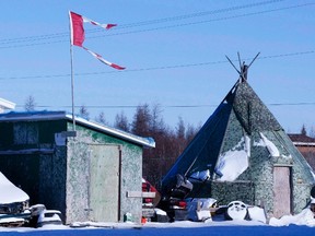 A tattered Canadian flag flies over a building in Attawapiskat, Ont., on November 29, 2011. A remote northern Ontario First Nation has declared a state of emergency after numerous suicide attempts this week. THE CANADIAN PRESS/Adrian Wyld