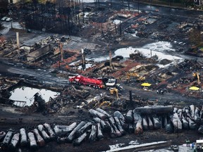 In this July 9, 2013 file photo, workers comb through debris after a train derailed causing explosions of railway cars carrying crude oil in Lac-Megantic, Quebec. (Paul Chiasson/The Canadian Press via AP, File)