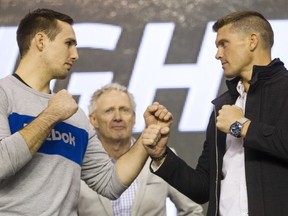 Rory MacDonald, left, and Stephen Thompson  square up for the cameras, while Tom Wright, UFC executive vice-president and general manager for Canada, Australia and New Zealand, center, looks on during a media availability for the June 18th UFC Fight Night match between MacDonald and Thompson at TD Place Monday April 11, 2016. (Darren Brown).