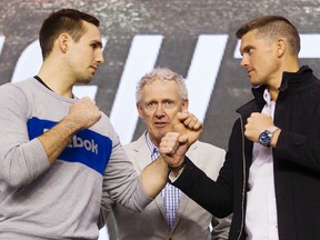 Rory MacDonald, left, and Stephen Thompson square off for the cameras, while Tom Wright, UFC executive vice-president and general manager for Canada, Australia and New Zealand, centre, looks on during a media availability at TD Place Monday April 11, 2016. (Darren Brown)