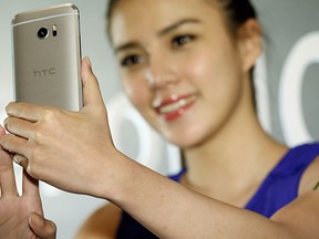 A model poses for photographs with HTC 10, an Android-based smartphone, during its launch event in Taitung, Taiwan April 12, 2016. REUTERS/Tyrone Siu