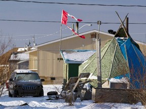 A tattered Canadian flag flies over a teepee in Attawapiskat, Ont., in this file photo taken Dec. 17, 2011. An aboriginal official in northern Ontario says a nine-year-old child and 12 other youths were overheard making a suicide pact Monday on a remote First Nation mired in a suicide crisis. (REUTERS/Frank Gunn/Pool/Files)