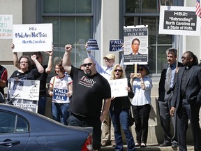 Opponents of House Bill 2 protest across the street from the North Carolina State Capitol in Raleigh, N.C., Monday, April 11, 2016 during a rally in support of the law that blocks rules allowing transgender people to use the bathroom aligned with their gender identity. (AP Photo/Gerry Broome)