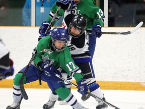 Sudbury Wolves Ben Doucette battles for the puck with Zacharie Giroux of the Nickel City Sons during the All-Ontario Peewee AAA Championship  in Sudbury, Ont. on Tuesday April 5, 2016. Gino Donato/Sudbury Star/Postmedia Network