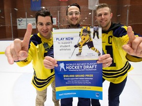 NAIT hockey player Corey Chorneyko, assistant coach Umberto Fiorillo, and team captain Scott Fellnermayr pose with a poster from the NAIT World's Richest Playoff Hockey Draft at the NAIT arena on Tuesday. (David Bloom)