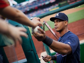 In this photo taken Sept. 3, 2015, Atlanta Braves Hector Olivera returns a ball as he signs autographs prior to start of a baseball game against the Washington Nationals at Nationals Park in Washington. (AP Photo/Pablo Martinez Monsivais)