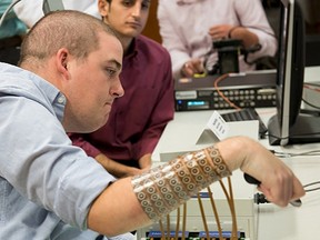 Ian Burkhart, 24, is shown using neural bypass technology in this undated handout picture released by Ohio State University Wexner Medical Center in Columbus, Ohio.Burkhart, who became paralysed in an accident, can now move his hands thanks to a computer chip in his brain that lets his mind guide his hands and fingers, bypassing his damaged spinal cord.  REUTERS/The Ohio State University Wexner Medical Center/Battelle/Handout via Reuters