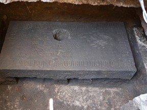 A massive stone slab lays near the Cathedral in Mexico City, Wednesday, April 13, 2016. Archaeologists found the slab covering the tomb of one of the first priests in Mexico following the 1521 European conquest, a grave sunk into the floor of what appears to be an Aztec temple. (AP Photo/Eduardo Verdugo)