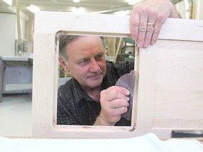 Marty Schlosser sands a cabinet in his home workshop in Kingston on Tuesday. Schlosser is a member of the Kingston Woodworkers Association, which is holding a woodworking symposium on Saturday. (Michael Lea/The Whig Standard)