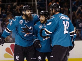 San Jose Sharks' Joe Pavelski, center, celebrates after scoring with teammates Brent Burns, left, and Joe Thornton during the third period of an NHL hockey game against the Arizona Coyotes Saturday, April 9, 2016, in San Jose, Calif. San Jose won 1-0. (AP Photo/Marcio Jose Sanchez)