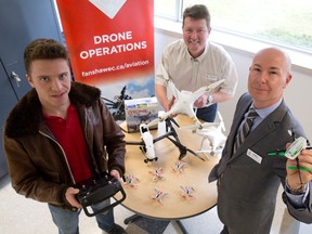 Fanshawe College aircraft maintenance student John Burgi, left, joins School of Transportation Technology instructor Mike Anderson and school chair Stephen Patterson as they show off some of the unmanned aerial vehicles (UAVs) that participants in the new UAV Operations continuing education program will use in class at the Fanshawe College hangar at the London International Airport in London, Ont. on Monday April 11, 2016. (CRAIG GLOVER, The London Free Press)