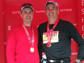 Running partners Brian Zimmer, left, and St. Thomas Fire Chief Rob Broadbent celebrate after qualifying for the Boston Marathon at the Scotiabank Toronto Waterfront Marathon in October 2014. The two are traveling to Massachusetts this weekend to participate in the big race Monday.