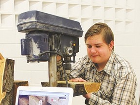 Abe Driedger, a 13-year-old Grade 8 student, uses a drill press to create a crib board at the Lomond Community School Spring Fair. Driedger, alongside partner Nolan Gartly, created handcrafted board games for their business, Campfire Games.