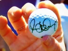 Brenda Kraemer, of Mitchell, holds an autographed golf ball of Rory McIlroy earlier last week at Augusta National golf course in Georgia. McIlroy hit a hole-in-one on the 16th hole and threw the ball into the gallery, which Brenda's husband Mike caught. SCREEN SHOT