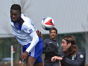 Tony Ameobi heads the ball away from a Minnesota United player during sunday's game a Clarke Stadium. (Ed Kaiser)