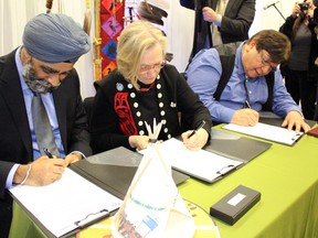 Minister of National Defence Harjit Sajjan (left), Minister of Indigenous and Northern Affairs Dr. Carolyn Bennett and Kettle and Stony Point Chief Tom Bressette sign the final Ipperwash settlement on Thursday, April 14, 2016 in Kettle and Stony Point, Ont. The agreement, ratified this past September, returns former Camp Ipperwash to the band as well as delivering a payment of $95 million. (Terry Bridge/Sarnia Observer/Postmedia Network)