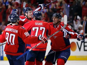 Capitals centre Marcus Johansson (90), right wing T.J. Oshie (77) and left wing Alex Ovechkin (8) celebrate with defenceman John Carlson (second from left) after his goal against the Flyers during the second period of Game 1 of their first-round NHL playoff series in Washington on Thursday, April 14, 2016. (Alex Brandon/AP Photo)