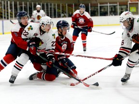 Brockville Braves forward Chris Chaddock, left, gets wrapped up by Ottawa Jr. Senators Cameron White, left, and Isaac Anderson as Liam Folkes moves into the play on Jan. 22. (Darcy Cheek, Postmedia Network)