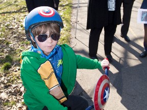 Six year old Jackson Cairns listens to deputy premier Deb Matthews announce funding for improved bicycle paths at Kiwanis Park in London on Friday. With Matthews are city councillor Michael van Holst (left) and Tecumseh mayor Gary McNamara. Derek Ruttan/The London Free Press/