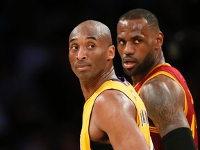 FILE - In this March 10, 2016 file photo, Los Angeles Lakers' Kobe Bryant, left, and Cleveland Cavaliers' LeBron James wait for play to resume during the first half of an NBA basketball game in Los Angeles. (AP Photo/Danny Moloshok, File)