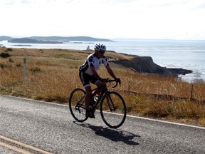 A cyclist rides by Cattle Point Lighthouse on San Juan Island, Wash., in this undated handout photo. For 75-year-old John Crouch, a bike ride of a thousand kilometres or more seems to be no big deal. To celebrate his 70th birthday he cycled from Whitehorse, Yukon, to his home in Victoria, an adventure recounted in his 2014 book "Six Highways to Home." THE CANADIAN PRESS/HO - John Crouch