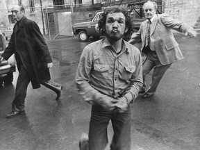 Whig-Standard file photo
Paul Arthur Lavigne, 32, the only person ever charged in the kidnapping of Janet Springer, lunges at Whig photographer William O’Neill as Lavigne is taken into court. In the background are Det.-Sgt. Bill Hackett, left, and Det. Harry Hickling. A 12-man jury convicted Lavigne on a charge of kidnap for ransom. Judge Alan Campbell sentenced him to six and a half years in prison.