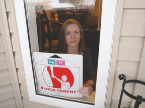 Spruce Grove Block Parent Program co-ordinator Aimee Hennig places her Block Parent sign in her window - Photo by Marcia Love.