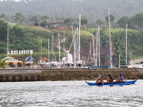 Fishermen on a small boat drives past the Oceanview resort on Samal island, Davao city, southern Philippines September 22, 2015. Two Canadian tourists, a Norwegian resort manager and a Filipino woman have been kidnapped by unidentified gunmen from a popular resort island in the southern Philippines, the army said on Tuesday. Philippines army Captain Alberto Caber said the four were taken at gunpoint during a raid late on Monday night on the Oceanview resort on Samal island, near Davao City, the largest city on Mindanao island in the restive southern Philippines.  REUTERS/Dennis Jay Santos