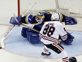 St. Louis Blues goalie Brian Elliott, left, deflects the puck as Chicago Blackhawks forward Patrick Kane watches Friday, April 15, 2016, in St. Louis. (AP Photo/Jeff Roberson)
