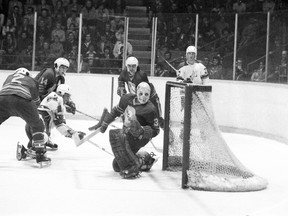 Hamilton Fincups goalie Mark Locken watches the puck sail wide of his net while Sudbury Wolves forward Rod Schutt is checked by Hamilton defenceman Mike Fedorko during an Ontario Major Junior Hockey League final game at Sudbury Community Arena on Wednesday, April 28, 1976. Sudbury Star/City of Greater Sudbury Archives