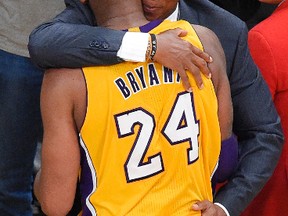 Lakers forward Kobe Bryant hugs coach Byron Scott as he comes out of the game during the second half against the Jazz in Los Angeles on Wednesday, April 13, 2016. (Mark J. Terrill/AP Photo)