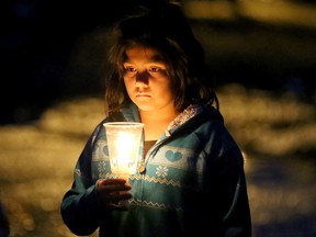 A candlelight prayer vigil was held as darkness fell over Attawapiskat, Friday April 15, 2016, with about 70 residents praying and singing as they walked through the reserve. In the wake of an epidemic of suicide attempts in Attawapiskat - including 11 young people last Saturday and a foiled suicide pact earlier this week - this remote northern Ontario reserve of 2,000 people declared a state of emergency over the weekend. (JULIE OLIVER/Postmedia Network)
