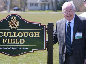 Donald 'Mic' McCullough stands beside the sign bearing his name following a dedication ceremony at Albert College where a new sports field was named in his honour on Saturday April 16, 2016 in Belleville, Ont. Tim Miller/Belleville Intelligencer/Postmedia Network