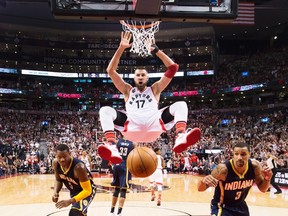 Toronto Raptors centre Jonas Valanciunas slam dunks the ball past Indiana Pacers Lavoy Allen and George Hill during second half round one NBA basketball playoff action in Toronto on Saturday, April 16, 2016.  (THE CANADIAN PRESS/Nathan Denette)