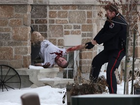 Kingston police carry an injured man from a townhouse on Crossfield Avenue following a standoff and fire on, Jan. 19, 2015. (Whig-Standard file photo)