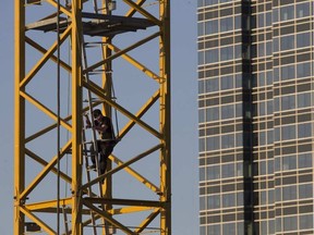 A man climbs down from a construction crane in the arena district, near 102 Street and 103 Avenue, on Sunday April 17, 2016.