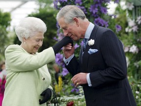 Prince Charles kisses the hand of his mother, Queen Elizabeth, during a visit to the Chelsea Flower Show in London in this May 18, 2009 file photo. (REUTERS/Sang Tan/Pool/Files)