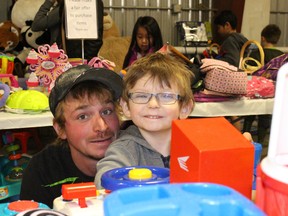Greg Wilson, left, and Darcy Jake Bobryk check out some of the items at the Rotary Garage Sale on Thursday night.