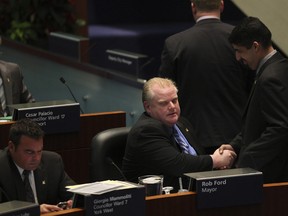 Toronto Mayor Rob Ford gets congratulated by chief of staff Nick Kouvalis after council voted to kill the car tax December 16, 2010. (Stan Behal/Toronto Sun files)