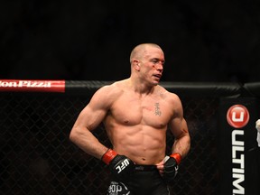 Georges St. Pierre takes a break during his fight with Nick Diaz at UFC 158 in Montreal's Bell Centre. (Postmedia Network file photo)