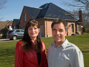 Jessica Mills and Paul Greer stand in front of a metal roof their company, Kind Roofing and Sheet Metal, installed on a house on Fitzwilliam Boulevard. (MIKE HENSEN, The London Free Press)