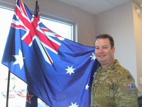 Lt.-Col. Andrew Behan, a liaison officer with the Australian army serving at Canadian Forces Base Kingston, standing with his country's flag, will be marking ANZAC Day on April 25. That is the day Australian and New Zealand troops landed at Gallipoli in 1915 and suffered heavy casualties. (Michael Lea/The Whig-Standard)